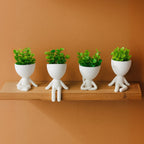 Kit com 4 mini vasos Mood em poses sentadas e flor artificial sobre prateleira de madeira.

