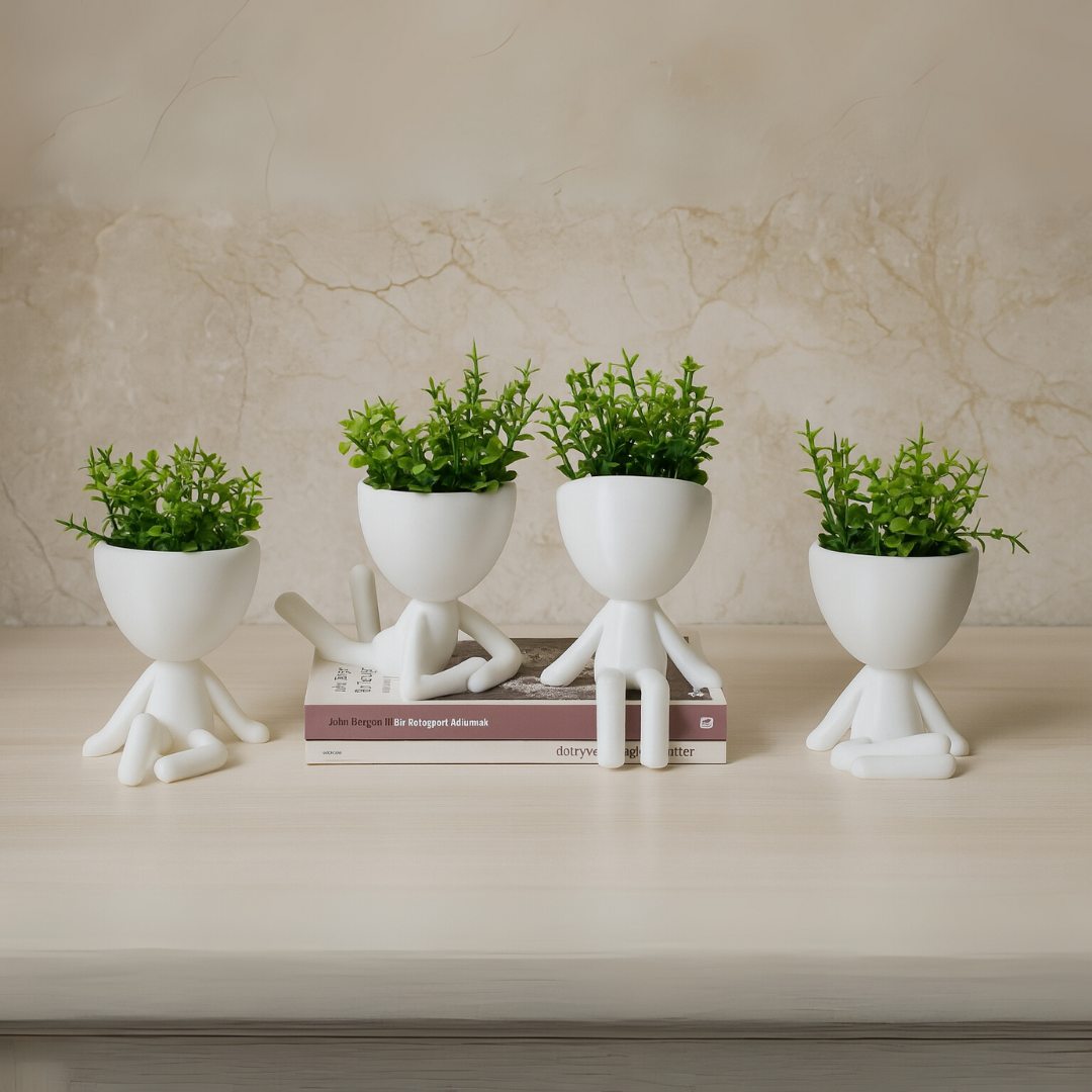 Mini vasos Mood com plantas decorativas sobre livros em ambiente claro e minimalista.

