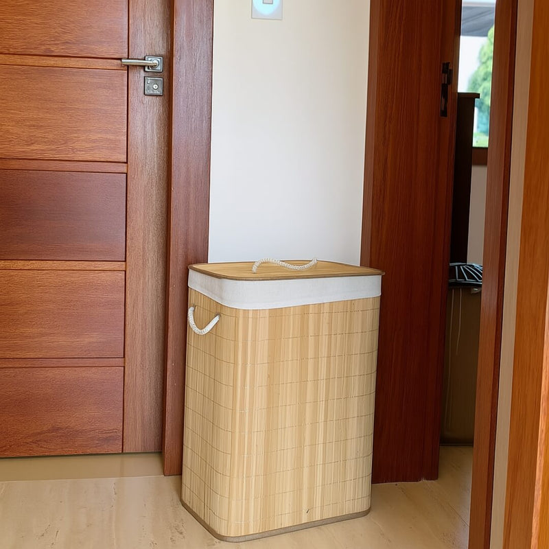Cesto de bambu retangular posicionado ao lado da porta de madeira em lavanderia moderna

