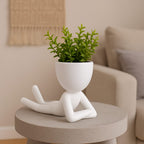 Mood Relaxando (de bruços) sobre mesa redonda de concreto em ambiente aconchegante.

