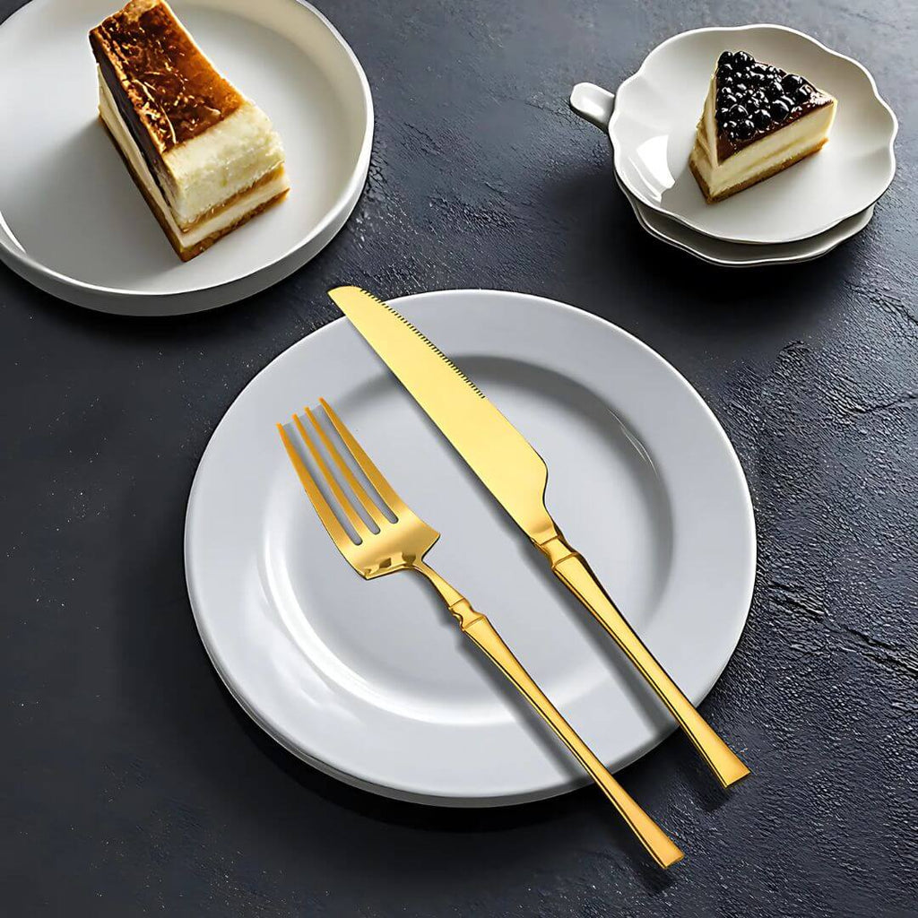 Faca e garfo dourados em uso na sobremesa, com louças brancas de porcelana

