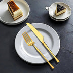 Faca e garfo dourados em uso na sobremesa, com louças brancas de porcelana

