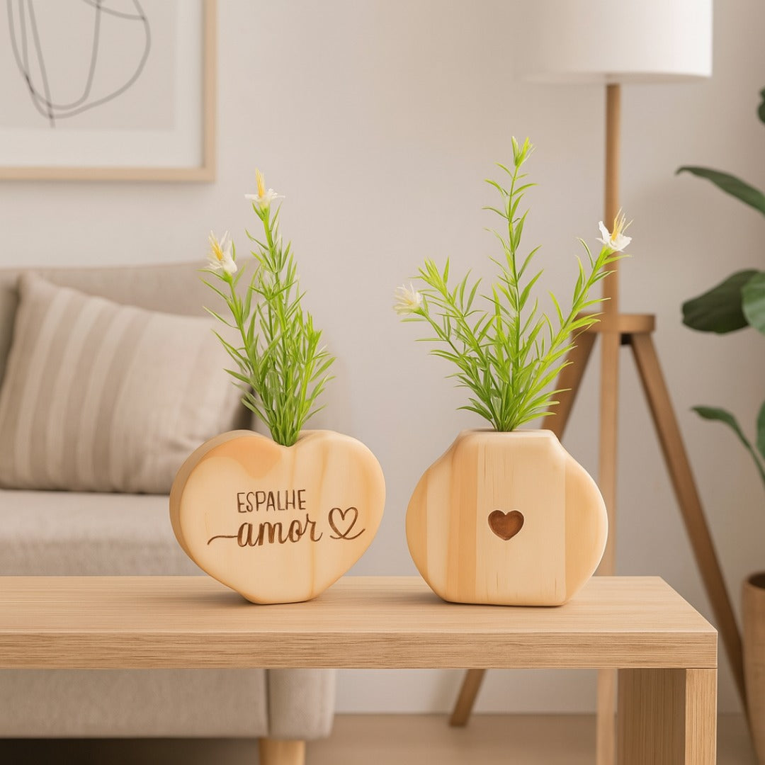 Vaso em formato de coração com frase "Espalhe amor" ao lado de vaso com coração vazado, sobre mesa de madeira clara em sala moderna

