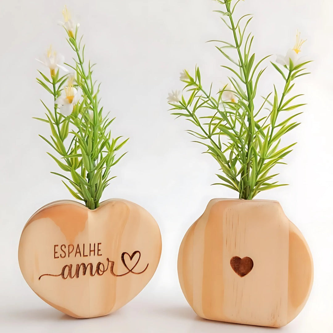 Vasos decorativos em madeira clara com flores artificiais, um com frase "Espalhe amor" e outro com coração entalhado


