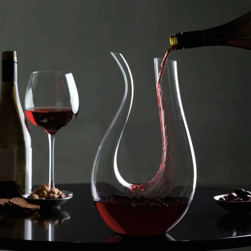 Decantador de vinho cristal moderno transparente em formato U na mesa posta

