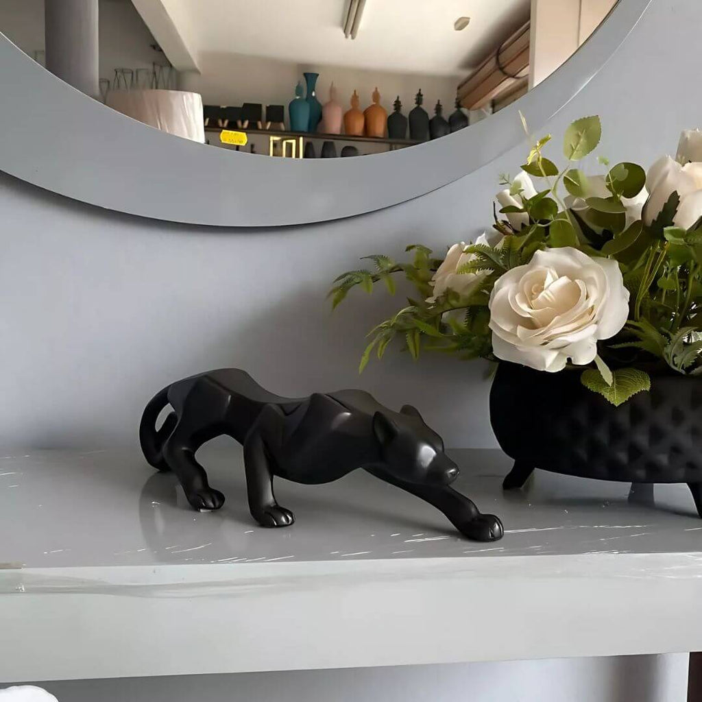 Detalhe de escultura animal preta fosca em ambiente contemporâneo


