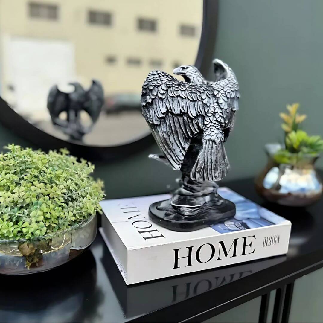 Objeto decorativo águia prata sobre livro, ideal para sala ou escritório

